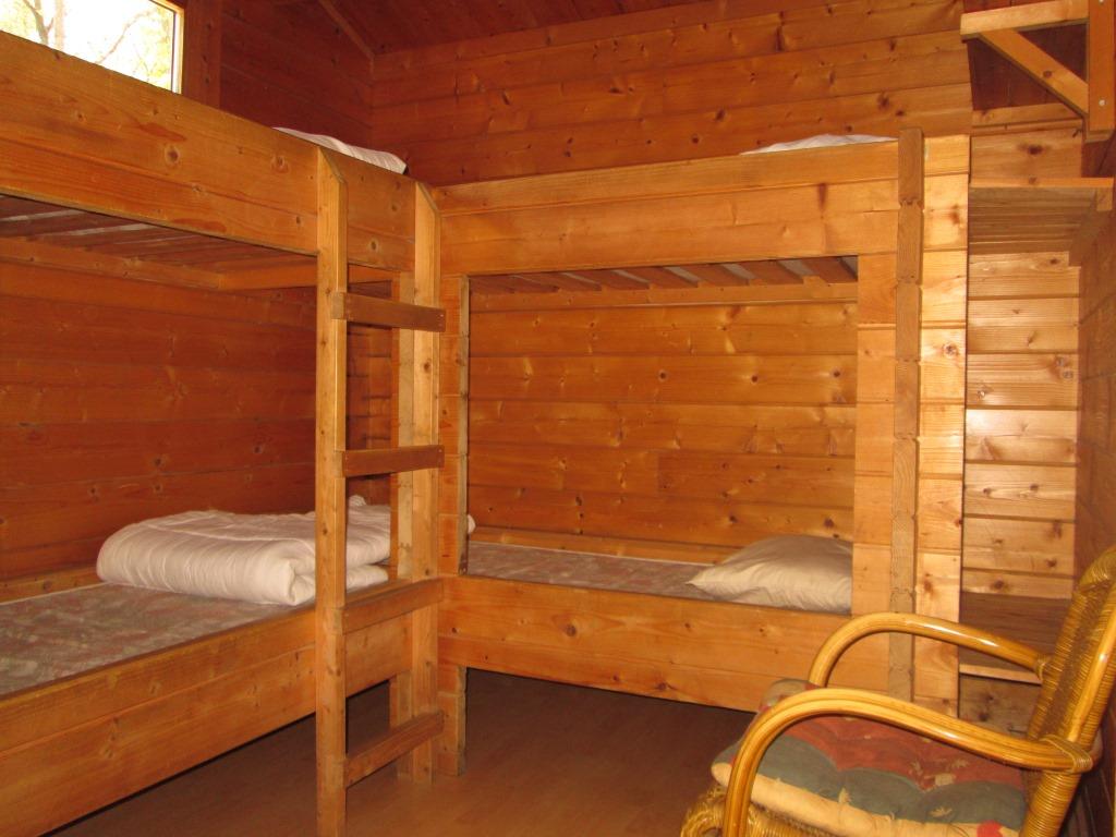 Er is een slaapkamer met een smal tweepersoonsbed en een slaapkamer met twee stapelbedden.